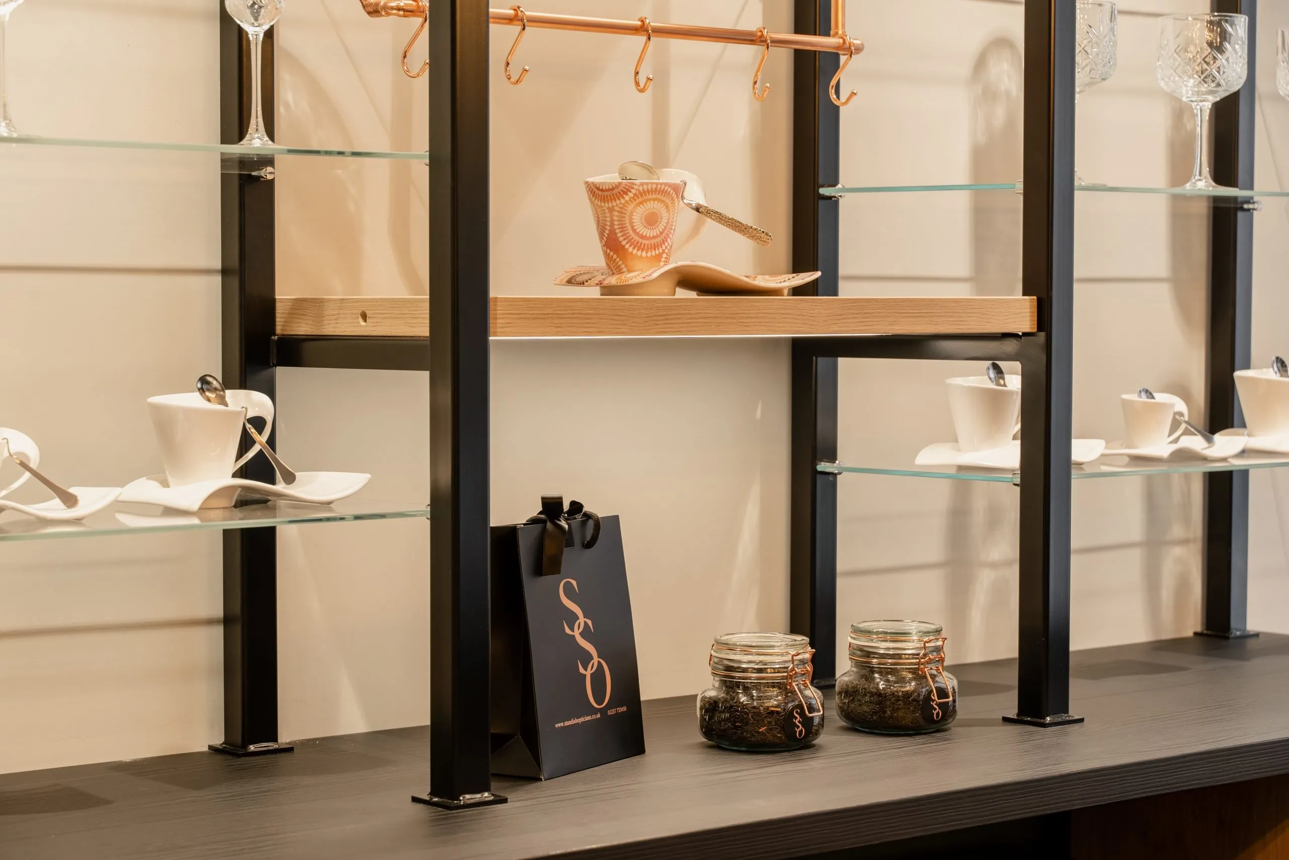 Cups, a gift bag and jars on the bar shelves at the practice