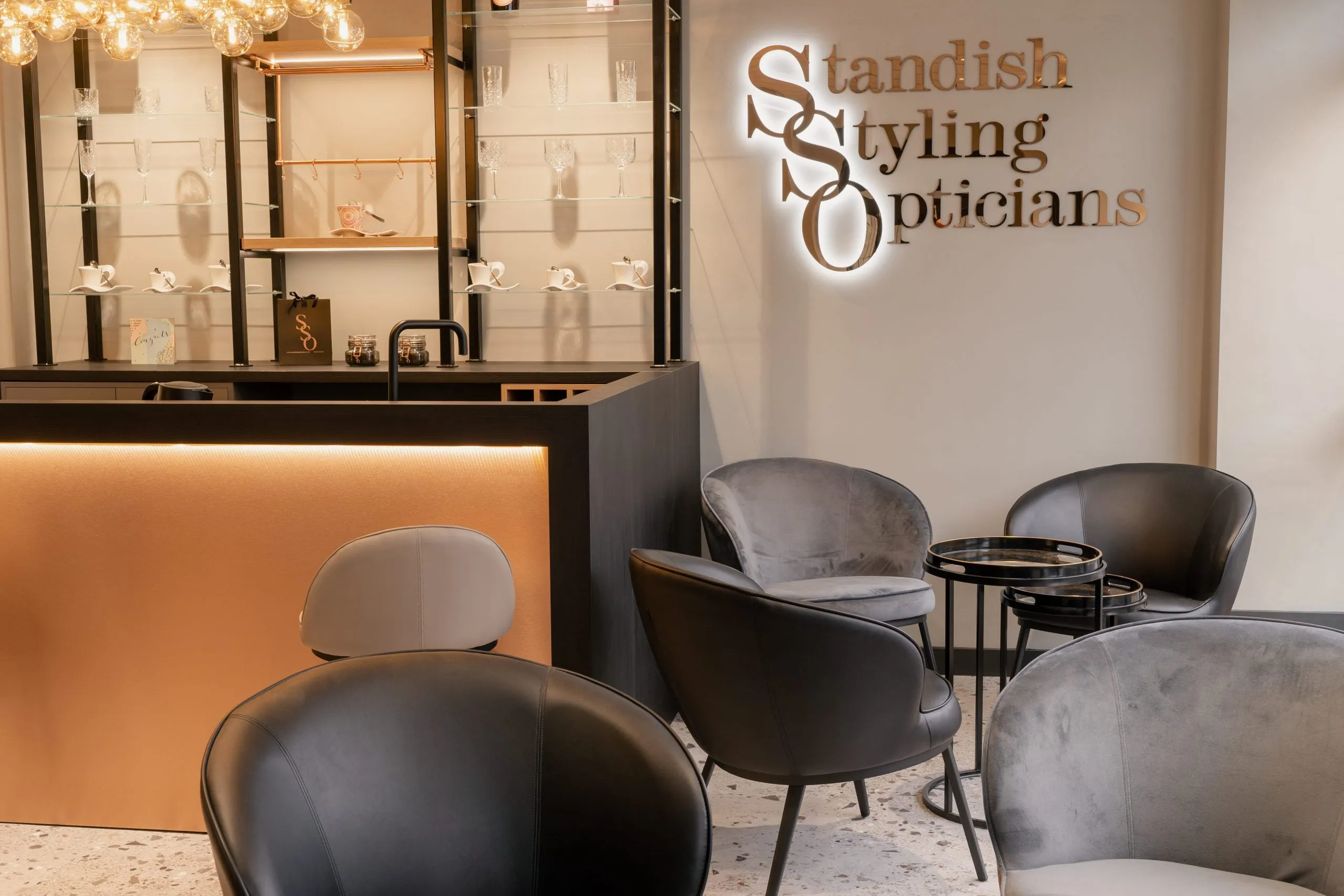 The bar and lounge chairs under the illuminated Standish Styling Opticians sign