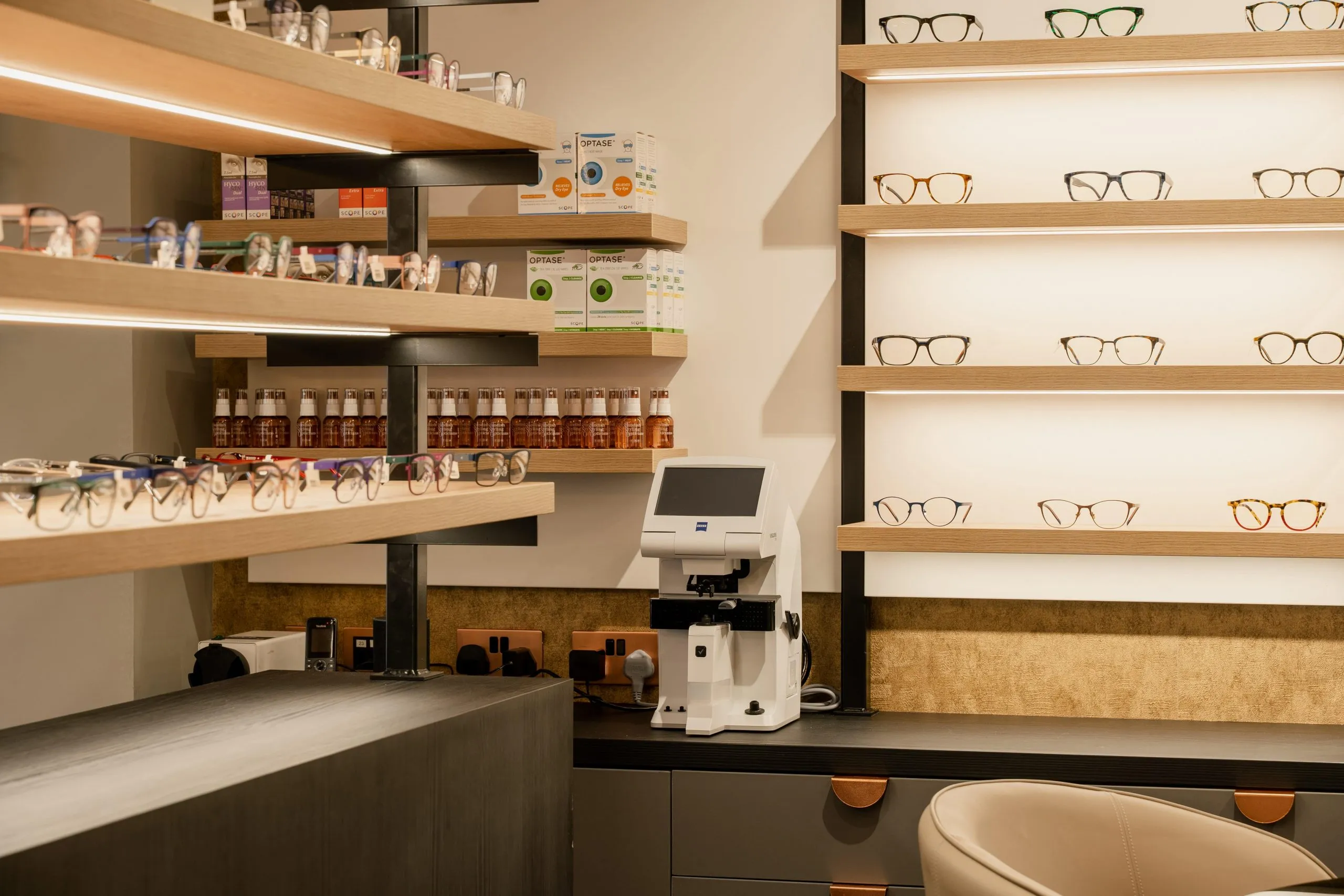 Shelves of glasses and contact lens solutions above the dispensing bench