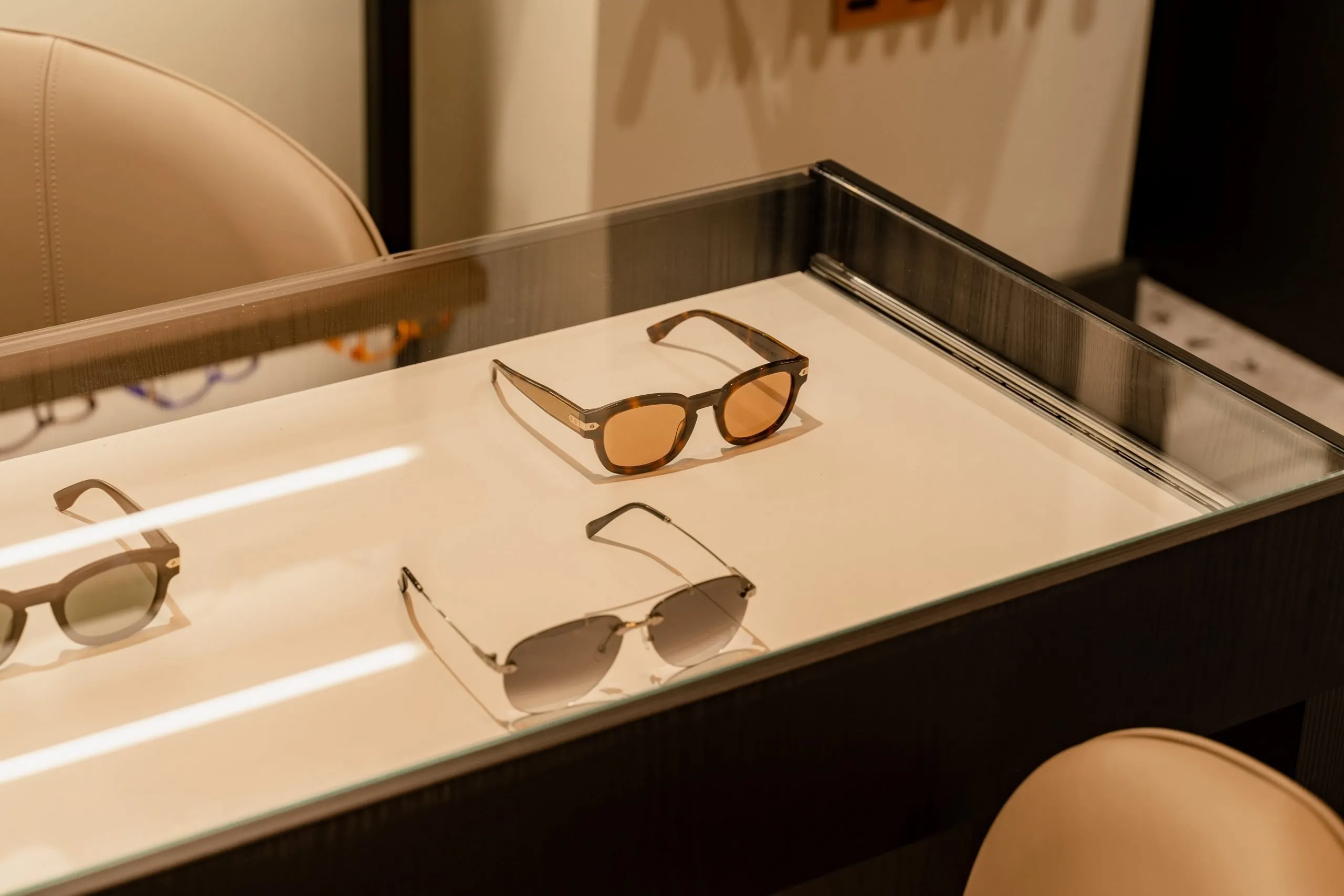 Sunglasses laid out in a lit glass display case